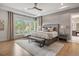 A serene main bedroom with a sitting area, large windows, and a tray ceiling at 1207 Wildcat Bend Ct, Castle Rock, CO 80108