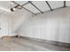 Spacious, unfinished two car garage with a concrete floor, garage door opener and white walls at 1222 S Reed Way, Lakewood, CO 80232