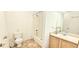 Bright bathroom with shower-tub combo, white tile, and vanity with wood cabinets at 1748 Eagle St # B, Aurora, CO 80011