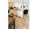Open kitchen with wood cabinets, stainless sink, and breakfast bar, opens to living area at 1748 Eagle St # B, Aurora, CO 80011