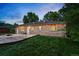 Well manicured backyard featuring brick house, grassy area, and lush green trees at 981 Ursula St, Aurora, CO 80011