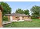 Spacious backyard with a brick house, patio, fire pit, and wooden deck, perfect for outdoor entertaining at 981 Ursula St, Aurora, CO 80011