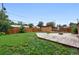 Large, fenced backyard featuring a wooden shed, stone fire pit, and partially covered patio area at 981 Ursula St, Aurora, CO 80011