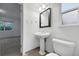 Bright bathroom featuring pedestal sink, updated mirror, and tiled floor at 981 Ursula St, Aurora, CO 80011
