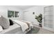 This bedroom has neutral colors, a plant for decor, and a large window overlooking a wooded area at 981 Ursula St, Aurora, CO 80011