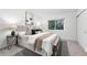 This bedroom has neutral colors, an accent bench, and large window looking out onto a wooded area at 981 Ursula St, Aurora, CO 80011