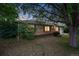 Well-maintained brick house with a lush green lawn, mature trees, and a driveway leading to a single-car garage at 981 Ursula St, Aurora, CO 80011