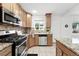 This kitchen offers plenty of cabinet space and a stainless steel dishwasher, stove, and microwave at 981 Ursula St, Aurora, CO 80011