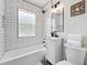 Bright bathroom features white subway tile, a shower-tub combination, vanity, and updated fixtures at 3344 W 33Rd Ave, Denver, CO 80211