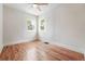 Empty bedroom showing natural light from the windows, hardwood floors, ceiling fan, and fresh paint at 3344 W 33Rd Ave, Denver, CO 80211