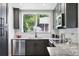 Updated kitchen features stainless steel appliances, sleek countertops, and modern gray cabinets at 3344 W 33Rd Ave, Denver, CO 80211