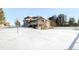 Brick home with deck, snow-covered yard, and partial view of outbuildings at 12247 Piney Lake Rd, Parker, CO 80138