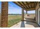 Covered patio with brick pillars, view of yard and outbuildings at 12247 Piney Lake Rd, Parker, CO 80138