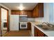 Functional kitchen with wood cabinets, white appliances, and adjacent laundry area provides practical convenience at 800 N Pearl St # 602, Denver, CO 80203