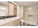 Modern bathroom with dual sinks, a large mirror, and a frameless glass shower with stylish tile at 7498 W Saratoga Pl, Littleton, CO 80123