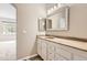 Bathroom featuring a vanity with double mirrors, marbled countertops, and wood-look vinyl flooring at 7498 W Saratoga Pl, Littleton, CO 80123