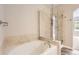 Bathroom featuring a soaking tub with tile surround and a glass-enclosed shower with tiled walls at 7498 W Saratoga Pl, Littleton, CO 80123