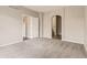 Spacious carpeted bedroom with neutral paint, closet and bathroom entrances, and plenty of natural light at 7498 W Saratoga Pl, Littleton, CO 80123