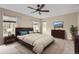 Staged bedroom features a large bed, windows with natural light, and a ceiling fan for added comfort at 7498 W Saratoga Pl, Littleton, CO 80123