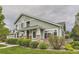 Inviting green home exterior featuring stone accents, manicured lawn, and beautiful landscaping at 7498 W Saratoga Pl, Littleton, CO 80123