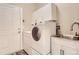 Well-organized laundry room with modern appliances and storage cabinets at 7498 W Saratoga Pl, Littleton, CO 80123