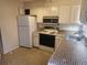A view of the kitchen with white cabinets, a stove, a microwave, and tiled floor at 805 E 7Th Ave # 8, Denver, CO 80218