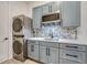 Basement laundry room with washer, dryer, sink, and modern gray cabinets at 3308 Carabiner St, Castle Rock, CO 80108