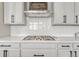 Modern kitchen with white shaker cabinets, herringbone backsplash, and gas cooktop at 3308 Carabiner St, Castle Rock, CO 80108