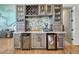 Custom wet bar with wine fridge, beverage fridge, and glass-front cabinetry at 3308 Carabiner St, Castle Rock, CO 80108