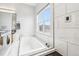 Bright, luxurious bathroom featuring a sleek tub with tile surround and scenic window view at 3644 Pinedale St, Boulder, CO 80301