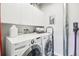 Bright laundry room with front loading washer and dryer and built-in white storage cabinets above appliances at 3644 Pinedale St, Boulder, CO 80301