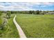 Aerial view of a lush green space with a winding path perfect for walking and recreation at 6251 W 74Th Ave, Arvada, CO 80003