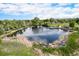 Scenic aerial view of a tranquil pond surrounded by lush greenery and walking paths at 6251 W 74Th Ave, Arvada, CO 80003