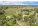 Expansive aerial view of a community park featuring walking trails, a playground, pond, green space and cityscape skyline at 6251 W 74Th Ave, Arvada, CO 80003