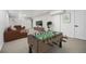 Basement with a foosball table, large brown sectional couch, and a wall-mounted TV for entertainment at 6251 W 74Th Ave, Arvada, CO 80003