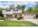 Charming two-story home with a well-manicured front yard, brick accents, and an attached two-car garage at 6251 W 74Th Ave, Arvada, CO 80003