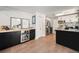 Charming kitchen boasts brick accent wall, modern appliances, wine storage, and sleek black and white cabinets at 6251 W 74Th Ave, Arvada, CO 80003