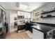 Updated kitchen featuring white brick walls, stainless appliances, and sleek black countertops at 6251 W 74Th Ave, Arvada, CO 80003