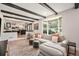 Bright living room with a comfortable couch and dark wood beam ceiling overlooks the kitchen at 6251 W 74Th Ave, Arvada, CO 80003