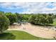 Aerial view of community playground with swings, slides, and climbing structures, surrounded by mature trees and lush landscaping at 6251 W 74Th Ave, Arvada, CO 80003