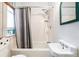 Bright bathroom featuring a white tiled shower, window with natural light and a pedestal sink at 2350 N Ogden St, Denver, CO 80205