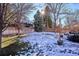 Large backyard with snow-covered grass and a wooden fence at 3481 Meadow Creek Pl, Highlands Ranch, CO 80126