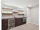 Basement bar with stone backsplash and shelving at 3481 Meadow Creek Pl, Highlands Ranch, CO 80126