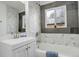 Updated bathroom showcasing modern vanity, unique tile design, and ample natural light through the window at 2056 Fulton St, Aurora, CO 80010