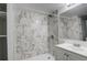 Modern bathroom featuring a walk-in shower with marble-look tile, sleek fixtures, and updated vanity at 2056 Fulton St, Aurora, CO 80010