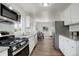 Modern kitchen featuring stainless steel appliances, white cabinetry, and a dining area with natural light at 2056 Fulton St, Aurora, CO 80010
