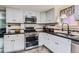 Well-lit kitchen features stainless steel appliances, white cabinets, and dark countertops at 230 Miner St, Idaho Springs, CO 80452
