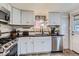 Bright kitchen with stainless steel appliances and white cabinets with black hardware at 230 Miner St, Idaho Springs, CO 80452
