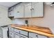 Updated laundry area with butcher block countertop, stylish cabinets, and ample storage space at 230 Miner St, Idaho Springs, CO 80452