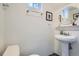 Compact powder room featuring a modern pedestal sink and decorative accents at 1235 Dahlia St, Denver, CO 80220